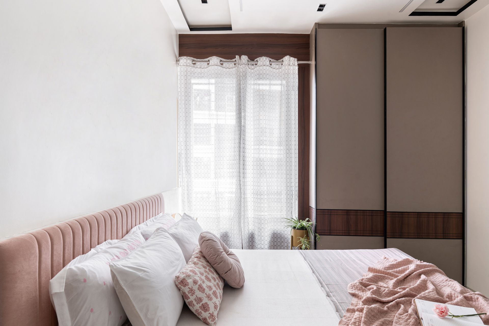 Bedroom with blush headboard and wardrobe